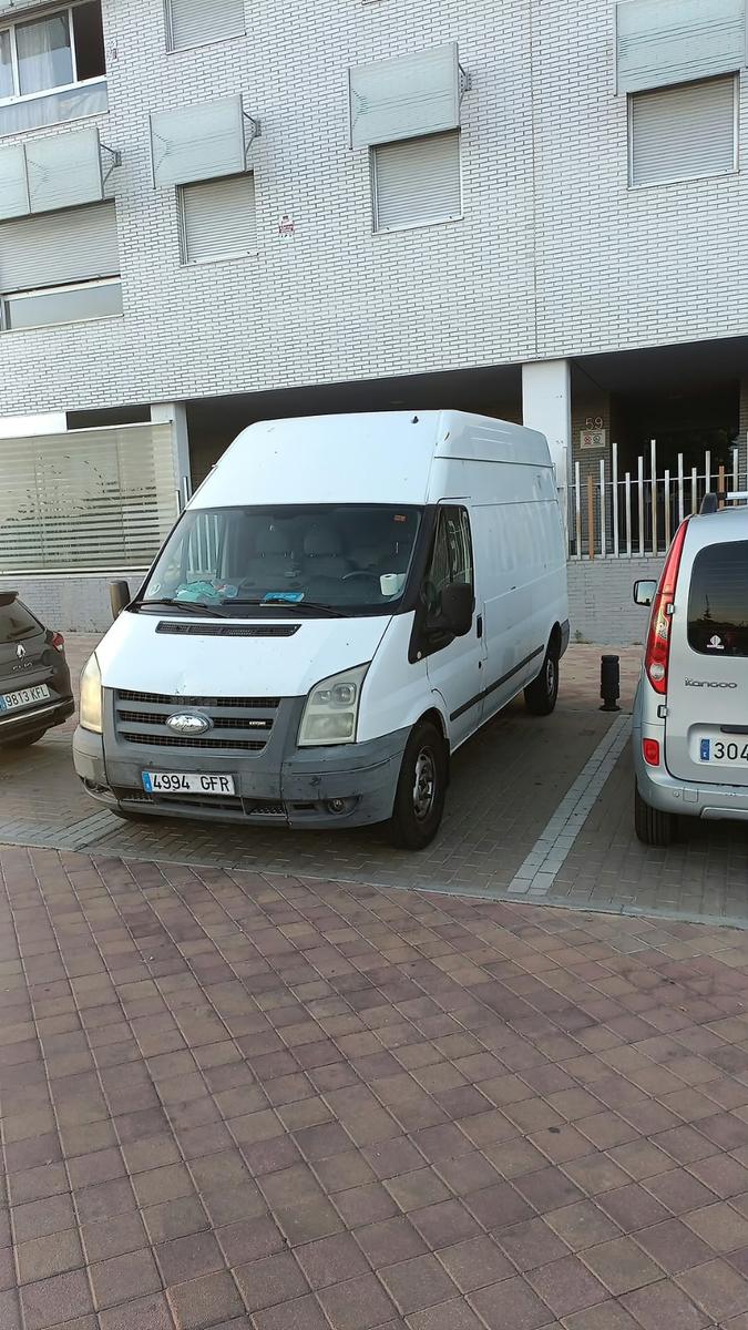 Furgón de Mudanzas Vallecas aparcado en el portal de un edificio para un porte